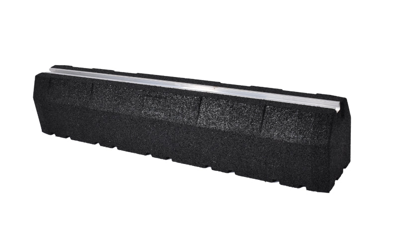 A long, black rubber mounting block, viewed from an angle, showcasing the textured material and the smooth silver aluminum track inset on top.